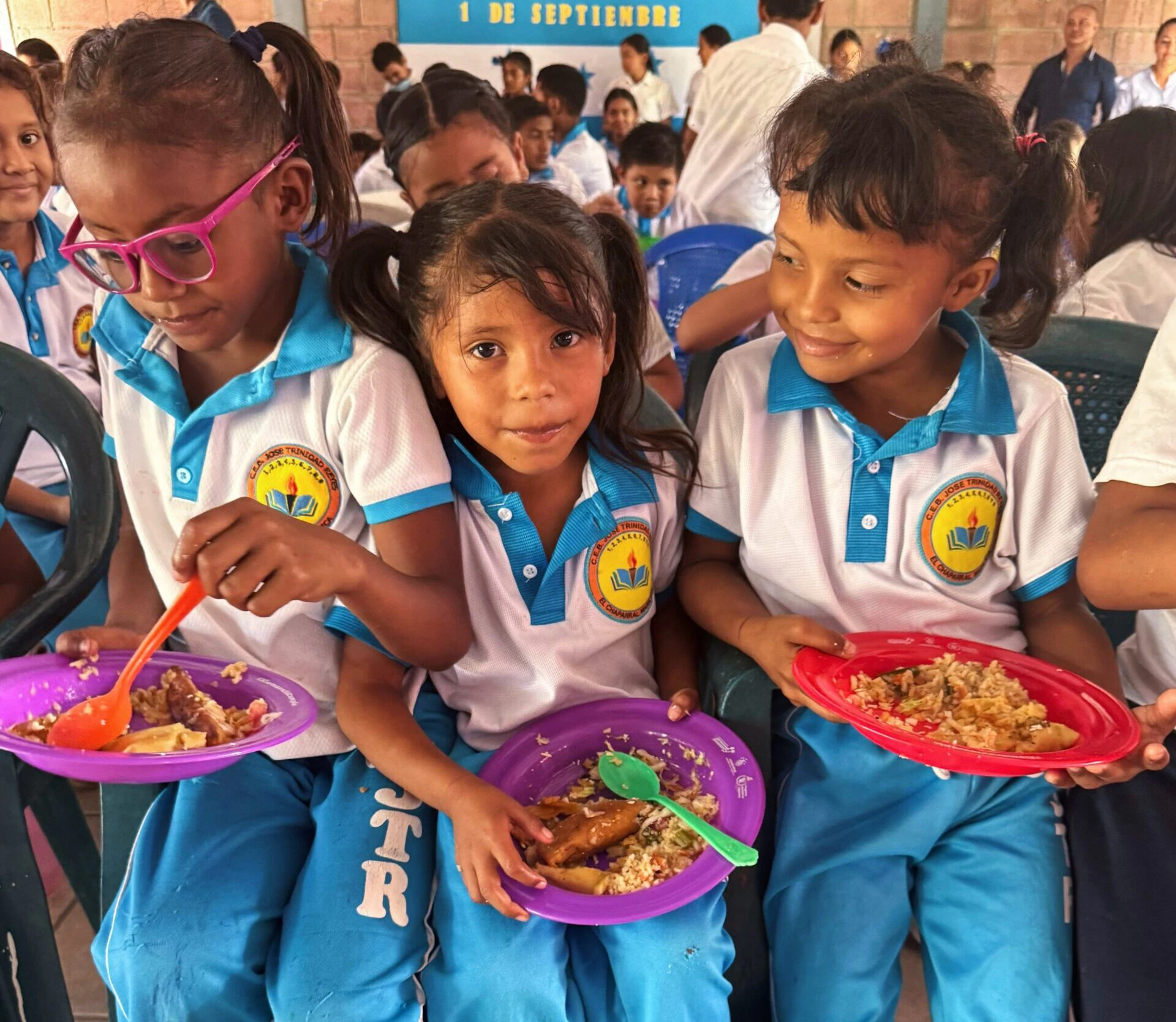 three young female students enjoy their lunch